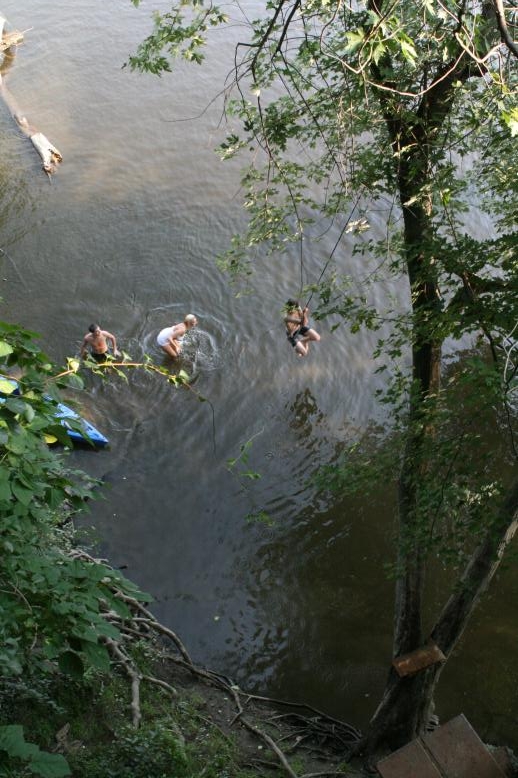 Young adults on a Conneticuit River Rope swing, Aug, 2009, North Hampton, MA at the Railtrail bridge.