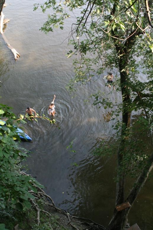 Young adults on a Conneticuit River Rope swing, Aug, 2009, North Hampton, MA at the Railtrail bridge.
