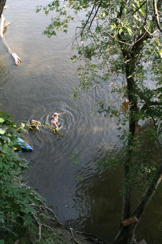 Young adults on a Conneticuit River Rope swing, Aug, 2009, North Hampton, MA at the Railtrail bridge.