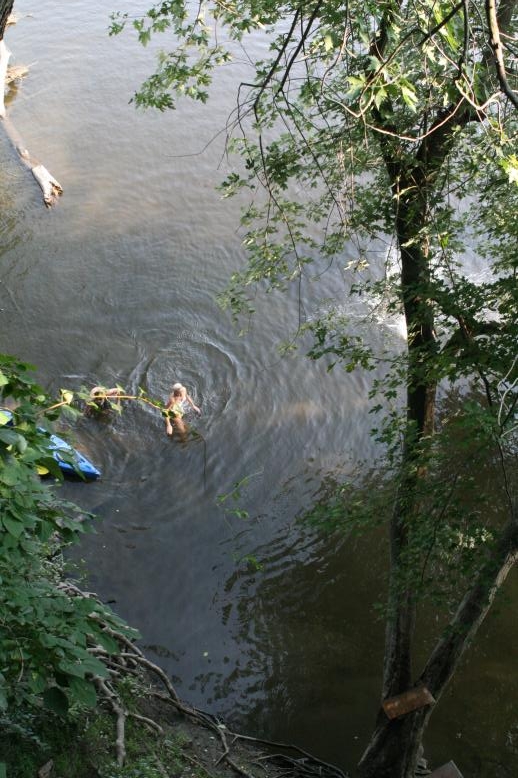Young adults on a Conneticuit River Rope swing, Aug, 2009, North Hampton, MA at the Railtrail bridge.
