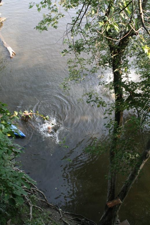 Young adults on a Conneticuit River Rope swing, Aug, 2009, North Hampton, MA at the Railtrail bridge.
