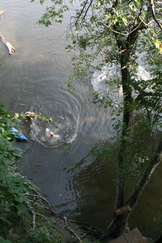 Young adults on a Conneticuit River Rope swing, Aug, 2009, North Hampton, MA at the Railtrail bridge.