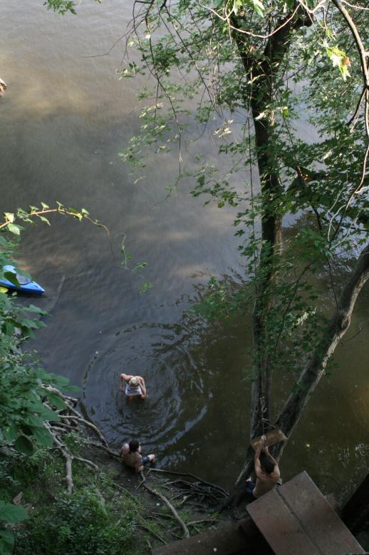 Young adults on a Conneticuit River Rope swing, Aug, 2009, North Hampton, MA at the Railtrail bridge.