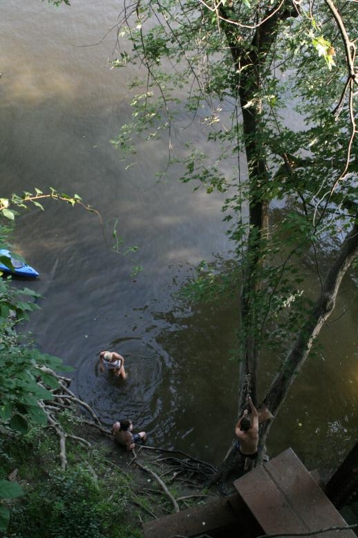 Young adults on a Conneticuit River Rope swing, Aug, 2009, North Hampton, MA at the Railtrail bridge.