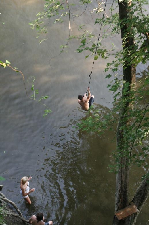 Young adults on a Conneticuit River Rope swing, Aug, 2009, North Hampton, MA at the Railtrail bridge.