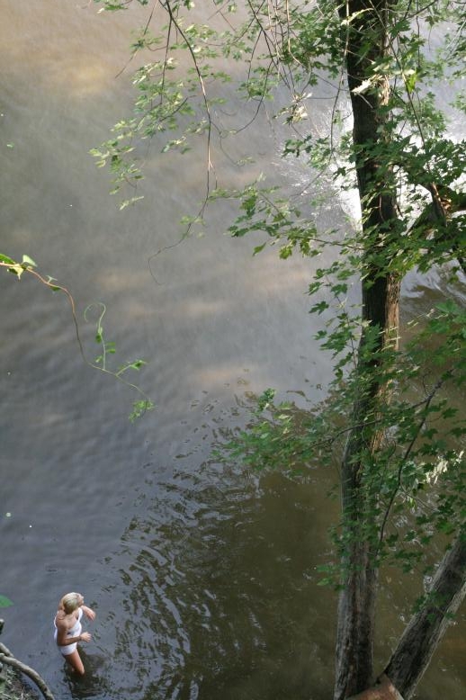 Young adults on a Conneticuit River Rope swing, Aug, 2009, North Hampton, MA at the Railtrail bridge.