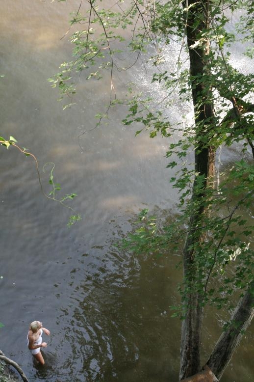 Young adults on a Conneticuit River Rope swing, Aug, 2009, North Hampton, MA at the Railtrail bridge.