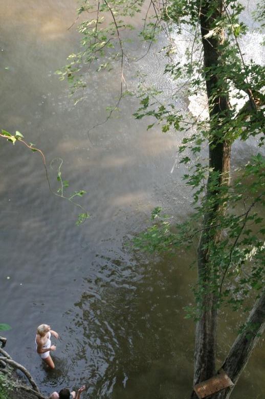 Young adults on a Conneticuit River Rope swing, Aug, 2009, North Hampton, MA at the Railtrail bridge.