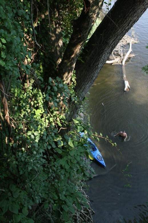 Young adults on a Conneticuit River Rope swing, Aug, 2009, North Hampton, MA at the Railtrail bridge.