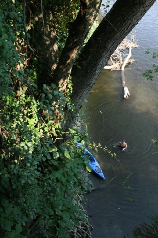Young adults on a Conneticuit River Rope swing, Aug, 2009, North Hampton, MA at the Railtrail bridge.