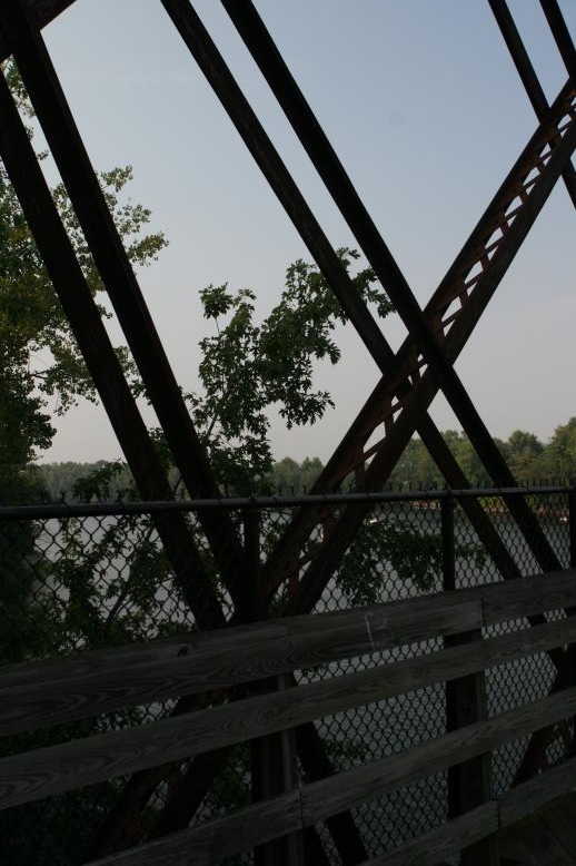Young adults on a Conneticuit River Rope swing, Aug, 2009, North Hampton, MA at the Railtrail bridge.