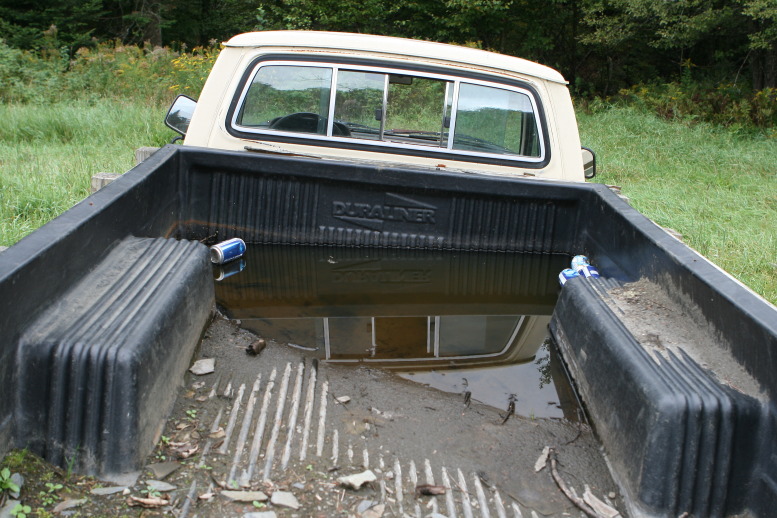 The Truck, abandoned at the Far Away Field Sept, 2011. Because of the rain the bed has water within it.  A couple of empty's float within the bedliner with in the collected rainwater.